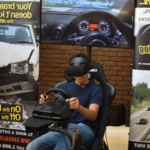 学生坐在驾驶模拟器上，戴着耳机遮住眼睛